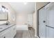 Bathroom featuring double sink vanity, soaker tub, and glass enclosed shower at 4060 Highway 81, Hampton, GA 30228