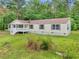 Charming single-story home with a white porch, set amidst a lush green lawn and mature trees at 4060 Highway 81, Hampton, GA 30228