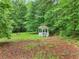 Tranquil backyard featuring a gazebo surrounded by mature trees, offering a peaceful retreat at 4060 Highway 81, Hampton, GA 30228