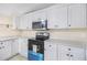 Modern kitchen boasts stainless steel microwave, a black range, and white cabinets at 4060 Highway 81, Hampton, GA 30228