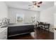 Cozy bedroom with dark wood floors, ceiling fan, and a desk area near the window at 505 Stedford Lane, Duluth, GA 30097