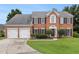 Charming two-story brick home featuring a manicured lawn, two car garage and classic shutters at 505 Stedford Lane, Duluth, GA 30097