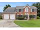 Traditional brick home with a two-car garage, manicured lawn, and mature landscaping at 505 Stedford Lane, Duluth, GA 30097