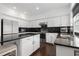 Modern kitchen with white cabinets, black backsplash and countertops, stainless steel appliances, and a central island at 505 Stedford Lane, Duluth, GA 30097