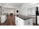 Bright kitchen with island and stainless steel refrigerator, open to the living space with dark wood floors at 505 Stedford Lane, Duluth, GA 30097