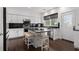This modern kitchen has white cabinets, black countertops, stainless steel appliances, and an island with seating at 505 Stedford Lane, Duluth, GA 30097
