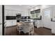 Bright kitchen offers white cabinets, black countertops and backsplash, stainless appliances, and an island with stools at 505 Stedford Lane, Duluth, GA 30097