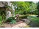 A backyard showcasing a stone path winding through manicured landscaping and lush greenery at 5140 Long Island Nw Dr, Sandy Springs, GA 30327