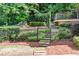 Landscaped backyard with stone steps leading to deck and garden area with metal fencing at 5140 Long Island Nw Dr, Sandy Springs, GA 30327