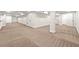 Spacious basement featuring neutral walls, carpet flooring, storage areas, and support pillars at 5140 Long Island Nw Dr, Sandy Springs, GA 30327