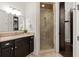 Bathroom featuring a glass enclosed shower, granite vanity, and travertine tile at 5140 Long Island Nw Dr, Sandy Springs, GA 30327