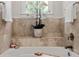 Bright bathroom featuring a white tub and travertine tile surround at 5140 Long Island Nw Dr, Sandy Springs, GA 30327