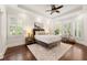 Serene bedroom featuring tray ceilings, plantation shutters, hardwood floors, and ample natural light at 5140 Long Island Nw Dr, Sandy Springs, GA 30327