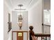 Hallway with dark wood banister and view to door and elegant light fixture at 5140 Long Island Nw Dr, Sandy Springs, GA 30327