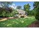 Front exterior of home with green lawn, mature trees, lush landscaping, and stone walkway at 5140 Long Island Nw Dr, Sandy Springs, GA 30327