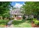 Charming two-story home with manicured lawn, mature trees, and a stone walkway leading to the front door at 5140 Long Island Nw Dr, Sandy Springs, GA 30327