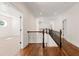 Bright hallway with wood floors, iron railing, and natural light at 5140 Long Island Nw Dr, Sandy Springs, GA 30327
