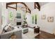 Inviting living room featuring a fireplace, wood beams, and large windows offering scenic views at 5140 Long Island Nw Dr, Sandy Springs, GA 30327