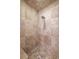 Shower with beige travertine tile and patterned mosaic flooring at 5140 Long Island Nw Dr, Sandy Springs, GA 30327