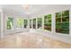 Light-filled sunroom with tiled floor and multiple windows providing views of the outdoors at 5140 Long Island Nw Dr, Sandy Springs, GA 30327