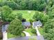 An aerial view shows the property near a golf course, mature trees, and beautiful landscaping at 10300 Carleigh Ln, Roswell, GA 30076