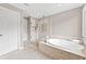 Bathroom featuring a soaking tub and glass-enclosed shower at 10300 Carleigh Ln, Roswell, GA 30076
