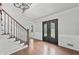 Grand foyer with hardwood floors, staircase, and decorative double doors at 10300 Carleigh Ln, Roswell, GA 30076