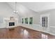 Living room with fireplace, wainscotting, and access to the outdoor living area at 10300 Carleigh Ln, Roswell, GA 30076
