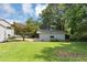 Backyard featuring a well-manicured lawn, some mature trees, and a detached garage at 2767 Kathie Ln, Ellenwood, GA 30294