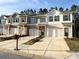 Inviting exterior view of three townhomes, showcasing neutral colors, front-entry garages, and well-manicured landscaping at 3341 Sable Elm Ct, Atlanta, GA 30349