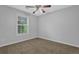Standard bedroom featuring a window and ceiling fan with neutral carpet at 3946 Village Crossing Ln, Ellenwood, GA 30294
