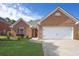 Charming one-story brick home featuring a manicured lawn and two-car garage at 3946 Village Crossing Ln, Ellenwood, GA 30294