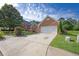 Brick home featuring an attached two-car garage and driveway, surrounded by green lawn at 3946 Village Crossing Ln, Ellenwood, GA 30294