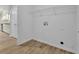 Bright laundry room with wood-look flooring, wire rack shelving, and washer-dryer hookups at 3946 Village Crossing Ln, Ellenwood, GA 30294