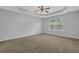 Large bedroom features tray ceilings, neutral walls and carpeting, and a ceiling fan at 3946 Village Crossing Ln, Ellenwood, GA 30294