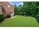Spacious backyard featuring a well-maintained lawn, brick accents, and mature trees, offering a serene outdoor space at 4435 Manor Creek Dr, Cumming, GA 30040