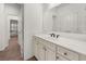 This bathroom features a white vanity with countertop sink, large mirror and a view into the hallway at 4435 Manor Creek Dr, Cumming, GA 30040