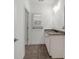 Bathroom featuring dark tile floor, light vanity with granite countertop, framed mirror, and linen closet at 4435 Manor Creek Dr, Cumming, GA 30040