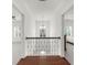 Hallway features hardwood floors and wrought iron railing, with views into the bedrooms at 4435 Manor Creek Dr, Cumming, GA 30040