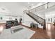 Bright, open-concept living room with hardwood floors and a view of the modern kitchen and staircase at 4435 Manor Creek Dr, Cumming, GA 30040