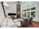 Living room with stone fireplace, large windows, white sofa and hardwood floors at 4435 Manor Creek Dr, Cumming, GA 30040