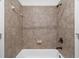 A tiled shower and tub combo with bronze fixtures, neutral walls and a built-in soap dish at 4435 Manor Creek Dr, Cumming, GA 30040