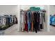 Large walk-in closet with clothes hanging on rods and storage shelves at 4435 Manor Creek Dr, Cumming, GA 30040