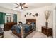 Cozy bedroom with a ceiling fan, dark wooden furniture, and lots of artwork at 6861 Louis Dr, Locust Grove, GA 30248