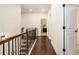 Long, bright hallway with hardwood floors and decorative iron railing on stairs at 6861 Louis Dr, Locust Grove, GA 30248