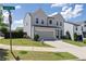 View of a lovely gray two-story home with a well-manicured lawn, and a two-car garage on a sunny day at 522 Evans Ln, Woodstock, GA 30188