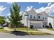 View of a lovely gray two-story home with a well-manicured lawn, and a two-car garage on a sunny day at 522 Evans Ln, Woodstock, GA 30188