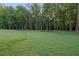 View of the expansive, green backyard surrounded by a lush treeline at 863 N Bay Overlook, Villa Rica, GA 30180