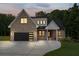 Beautiful exterior view of modern home with brick, black trim and a driveway at dusk at 863 N Bay Overlook, Villa Rica, GA 30180