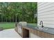 Stainless steel grill and sink with custom wood cabinetry in outdoor kitchen, perfect for grilling at 863 N Bay Overlook, Villa Rica, GA 30180